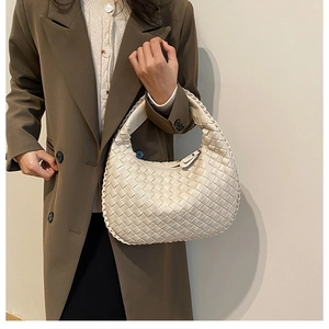 Close-up of a hand-woven cream hobo bag showing the intricate leather texture and knot design