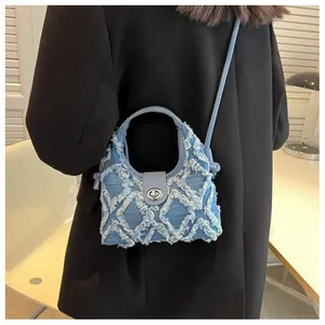 Blue denim crossbody bag with quilted lattice patterns and silver turn-lock closure