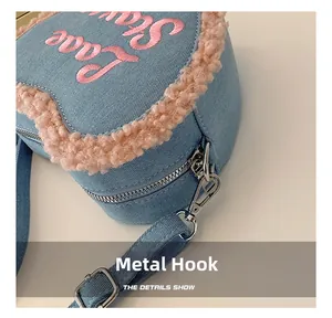 Détail du crochet en métal argenté sur un sac à bandoulière en denim en forme de cœur rose