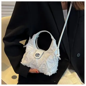 Detail of white textured tassel bag featuring silver twist lock and round handle