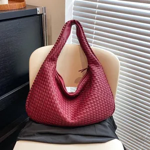 Dettaglio della trama in pelle intrecciata di una borsa hobo bordeaux con cerniera