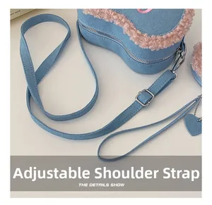 Détail de la bandoulière réglable d'un sac en denim en forme de cœur avec bordure en peluche