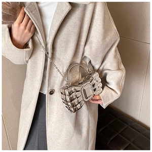 Silver metallic bow clutch featuring a large central crystal and a fine metal chain strap