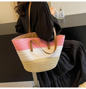 Detail of color-block straw tote with pink, white, and beige weave and leather handles