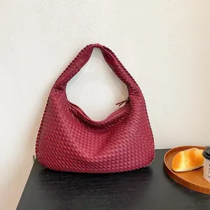 Dettaglio della trama in pelle intrecciata bordeaux di una borsa hobo