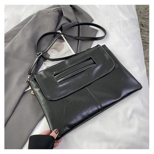 Detail of black rectangular crossbody bag with natural wrinkled texture and top handle