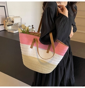 Detail of three-color straw tote bag with pink and white panels and leather straps