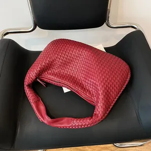Dettaglio della borsa hobo rossa intrecciata a mano con trama in pelle a rombi