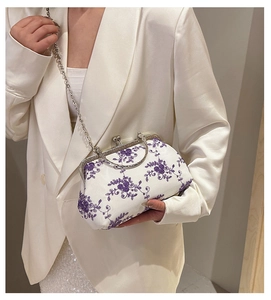 Detail of elegant white lace chain bag with purple floral embroidery and vintage metal clasp