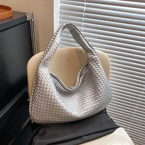 Dettaglio della trama intrecciata argento e della tracolla larga di questa borsa hobo