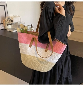 Detail of a tri-color woven straw tote bag with leather straps for beach outings