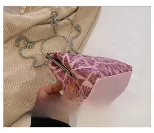 Detail of pink sequin clutch with silver ring handle and metal chain strap