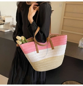 Close-up of tricolor straw tote bag featuring pink, white, and beige woven panels
