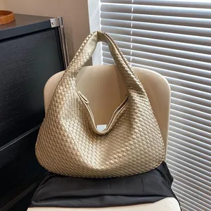 Dettagli dell'intreccio in pelle oro champagne e interno spazioso della borsa hobo