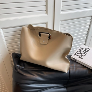 Minimalist beige leather tote bag with silver ring clasp and embossed text on black leather