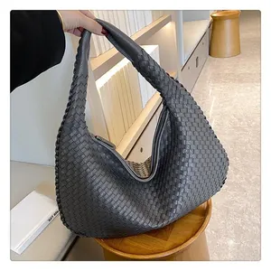 Dettaglio macro della borsa hobo intrecciata con texture in similpelle e motivi a griglia