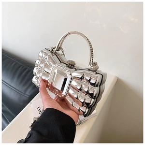 Macro shot of silver bow evening bag with diamond handle and crystal center detail