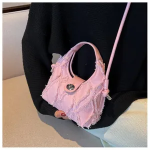 Detail of pink frayed denim crescent bag with metal twist lock and leather handle