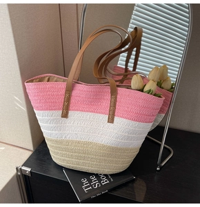 Close-up of pink and white striped woven straw tote bag with brown leather handles