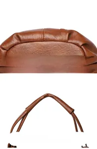 Close-up of precise stitching and ergonomic handle on brown lychee leather handbag