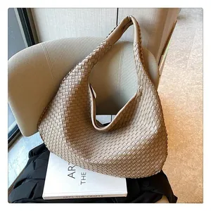 Dettaglio ravvicinato della borsa hobo beige in pelle intrecciata su sedia