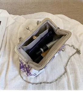 Detail view of the elegant lace purse interior with purple floral embroidery and chain