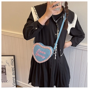 Détail du sac coeur en denim bleu avec bordure rose en peluche et broderie Love Story