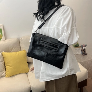 Minimalist black oil-wax leather shoulder bag with vintage flap and adjustable strap