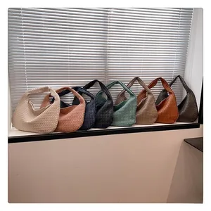 Dettaglio di varie borse hobo a spalla intrecciate colorate in diverse tonalità di pelle