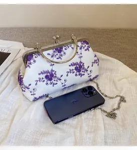 Detail of floral lace embroidery on vintage-style bag with silver metal handle