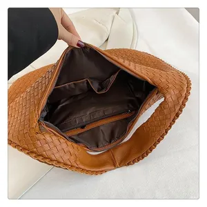 Vista interna della borsa hobo intrecciata marrone con fodera e tasca con cerniera