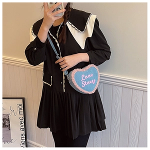 Détail d'un sac cœur en denim bleu avec bordure rose pelucheuse et broderie Love Story