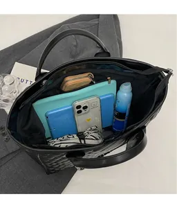 Interior view of large black quilted tote bag showing spacious storage for tablet and daily items