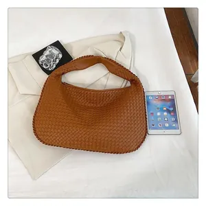 Primo piano della borsa hobo intrecciata marrone con grande capacità e trama tessuta