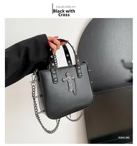 Macro detail of gothic black PU leather bag featuring silver studs and cross pendant