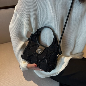 Vintage black denim crescent bag with quilted pattern and silver lock worn by model