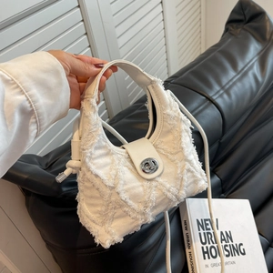 Chic white denim tassel crossbody bag with quilted texture and silver rotary lock