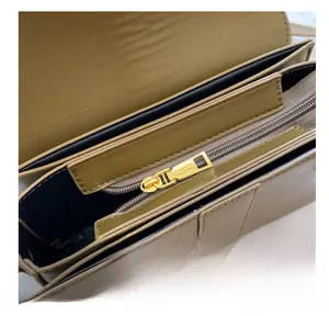 Détail intérieur du sac beige montrant les compartiments multicouches et le zip doré