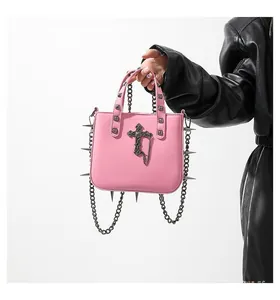 Pink gothic leather handbag with metal spikes, black cross, and silver chain detail