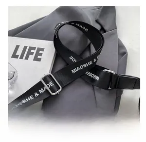 Adjustable wide black woven shoulder strap with white logo print and silver buckle