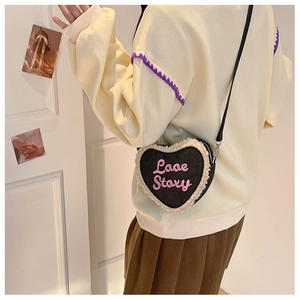 Détail du sac bandoulière en forme de cœur avec bordure en fourrure et broderie