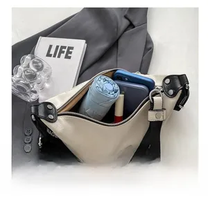 Internal view of beige crossbody bag showing space for phone, umbrella and lipstick