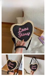 Détail du sac en denim en forme de cœur avec bordure en peluche et broderie rose