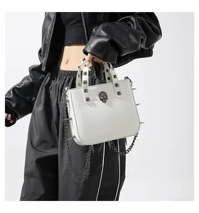 Macro shot of white leather punk bag featuring metallic skull and silver rivets details