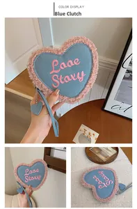 Détail de la pochette en jean bleu en forme de cœur avec bordure rose et broderie