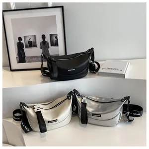 Three colors of crescent moon crossbody bags displayed on minimalist white stairs
