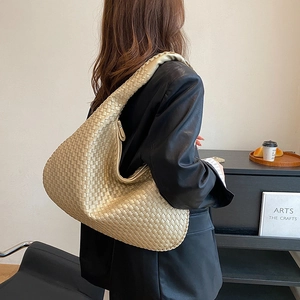 Borsa hobo dorata in pelle intrecciata con motivo trapuntato da donna indossata sul modello
