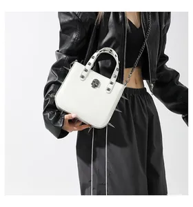 Close-up of white punk crossbody bag with silver spikes and skull metal ornament
