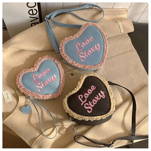 Détail du sac en denim en forme de cœur avec bordure en fourrure et broderie