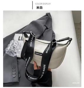 Chic beige crescent bag on grey blazer with a trendy logo adjustable wide strap